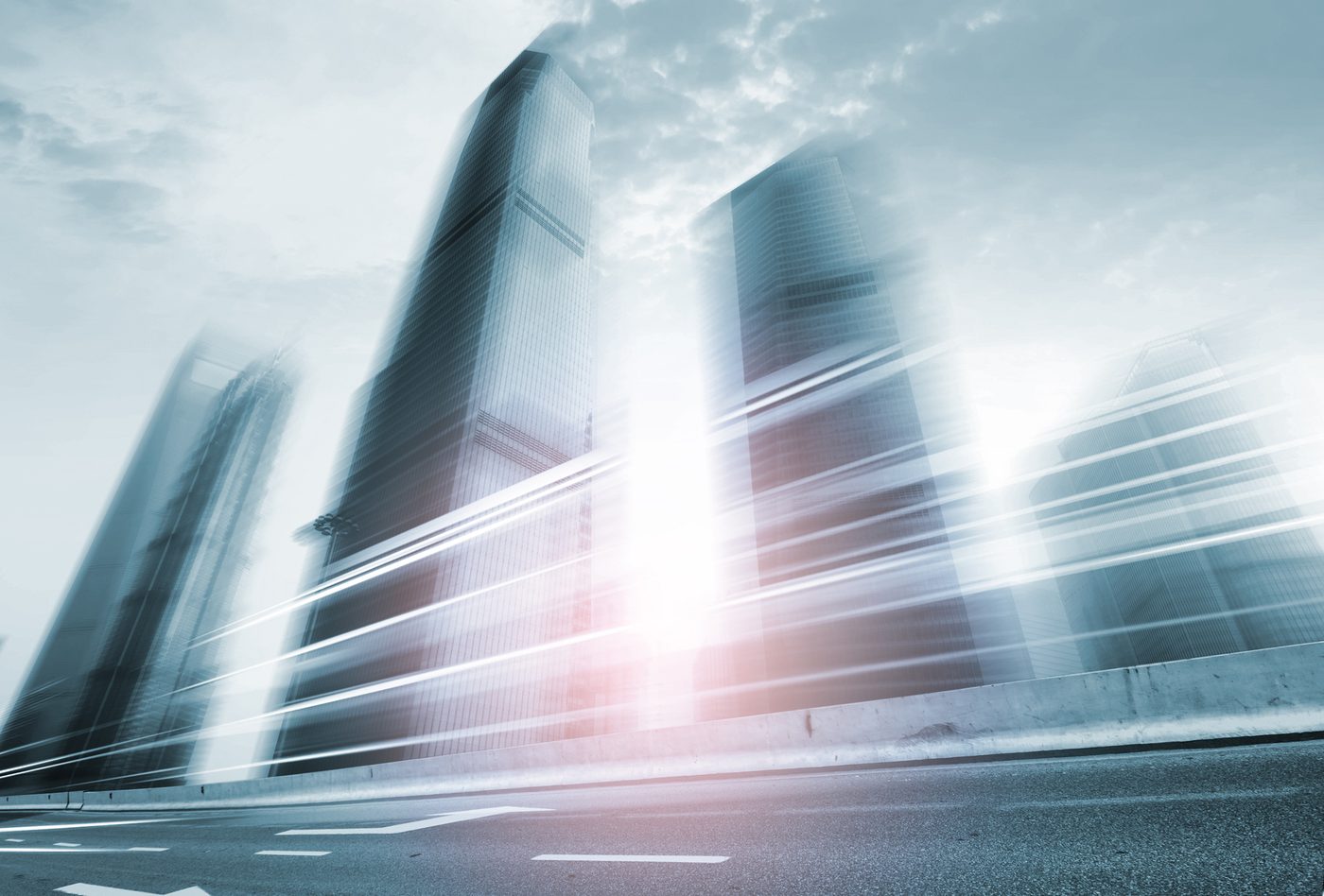Glass office towers rising into a bright sky