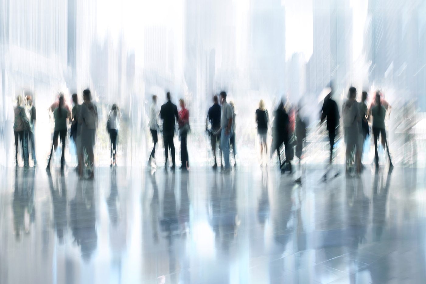 Blurred crowd of people walking through a bright hall